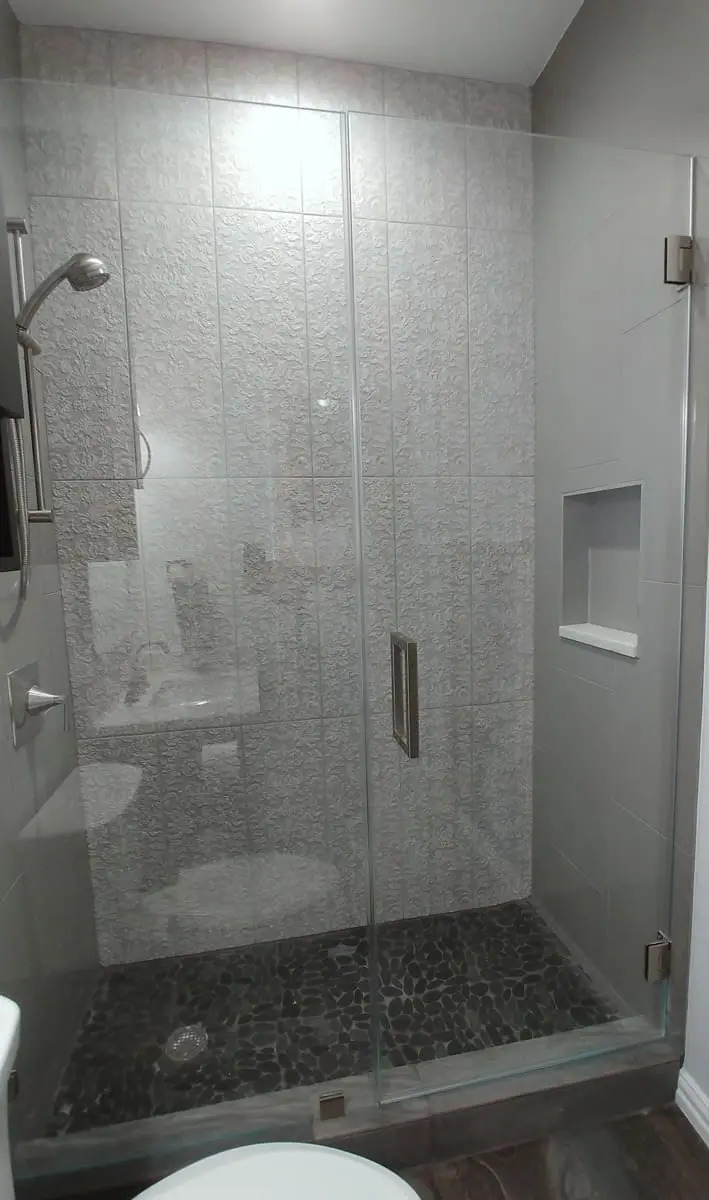 A bathroom with a shower and tiled walls.