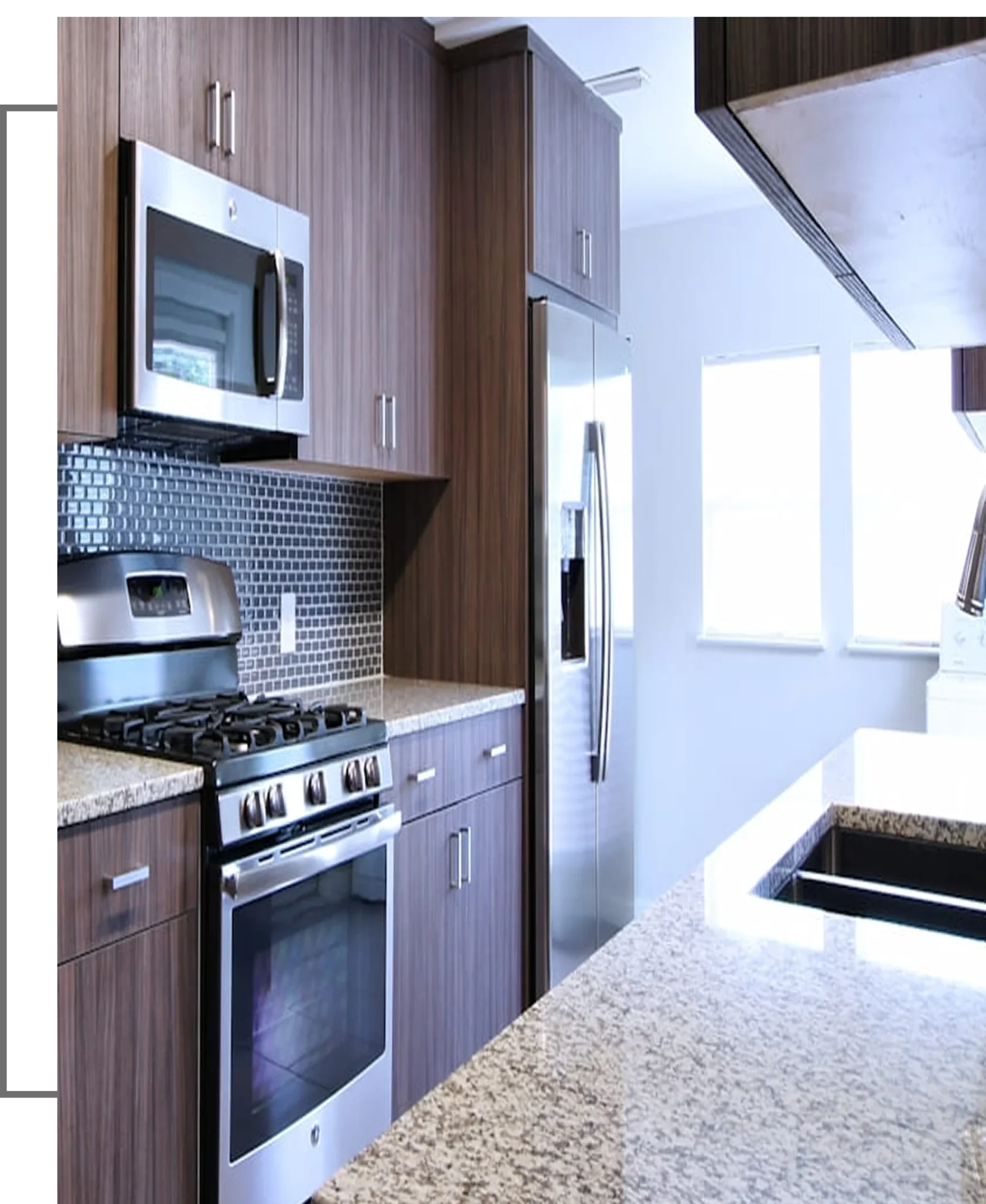 Modern kitchen with stainless steel appliances, including a microwave, oven, and fridge. Dark wooden cabinets, granite countertops, and a tiled backsplash are featured.